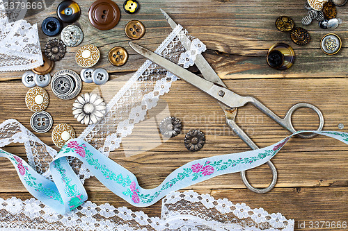 Image of aged lace, vintage buttons and a dressmaker scissors