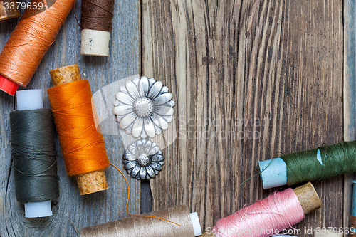 Image of vintage buttons and old reels of varicolored thread