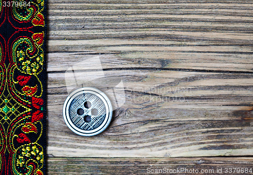 Image of old band with embroidered ornaments and vintage button