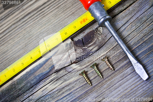 Image of antique screwdriver, screws and measuring lenght 