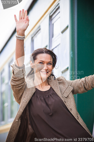 Image of woman waving hand from the passenger wagon