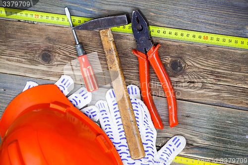 Image of Vintage pliers, hammer, screwdriver, tape measure, a bright helm