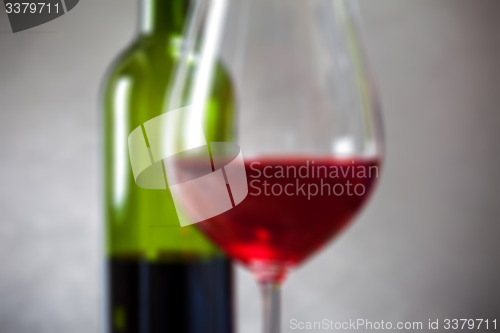 Image of red wine in goblets and green bottle