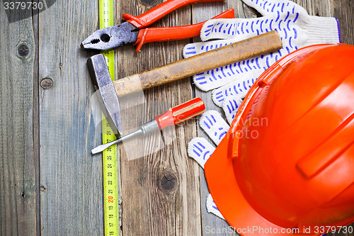 Image of Vintage hammer, pliers, screwdriver, tape measure, a bright helm