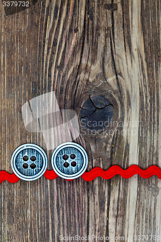 Image of old red tape and two vintage classic buttons