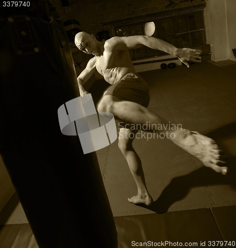 Image of Kick boxer trains on punching bag