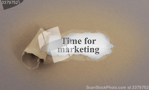 Image of Text appearing behind torn brown envelop
