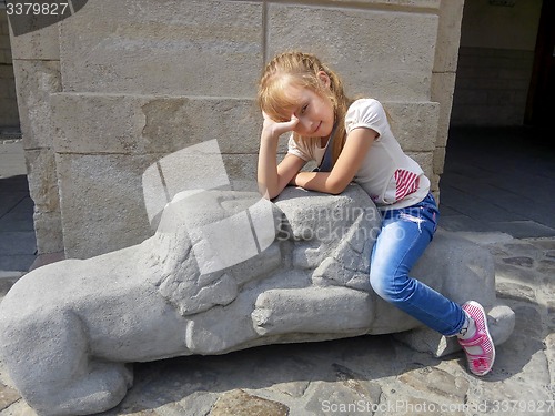 Image of Little girl sitting on the lions sculpture