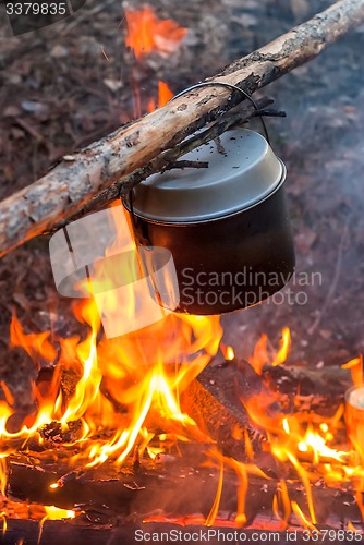 Image of Water heating in camping kettle on fire