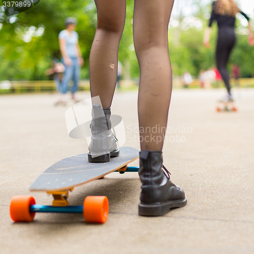 Image of Girl practicing urban long board riding.