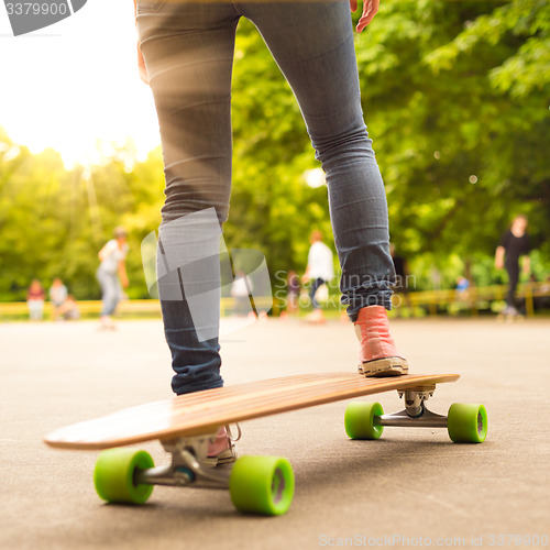 Image of Girl practicing urban long board riding.