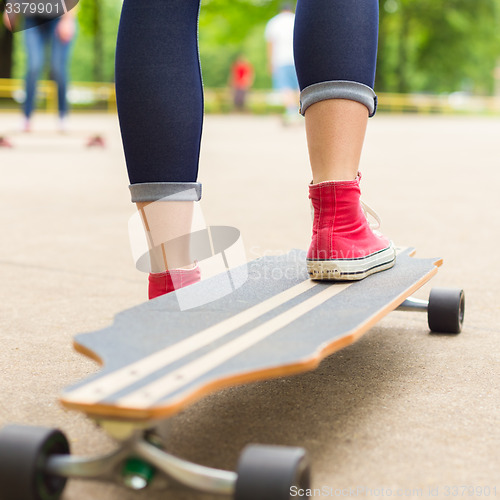 Image of Girl practicing urban long board riding.