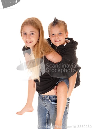 Image of Young pretty girl is piggybacking little brother.