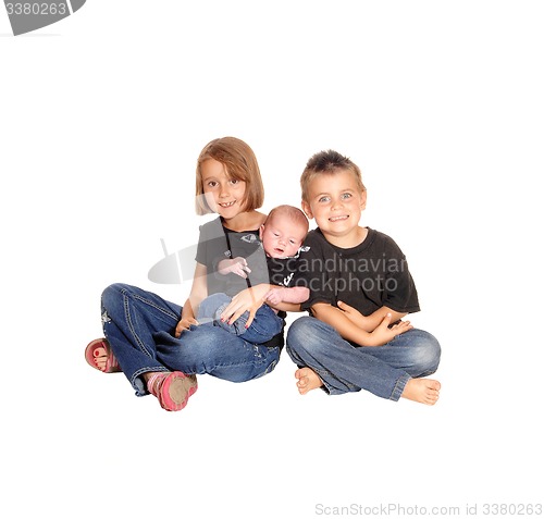 Image of Sister and brother holding new baby.