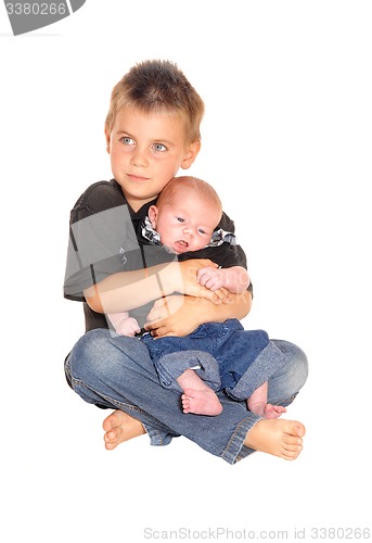 Image of Little boy holding his three weeks old brother.