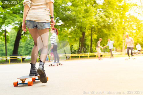 Image of Teenage girl urban long board riding.