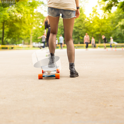 Image of Teenage girl urban long board riding.