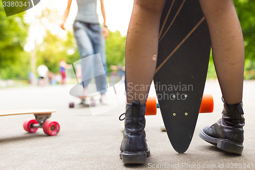 Image of Teenage girl urban long board riding.