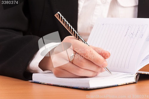 Image of Business woman writing in notebook