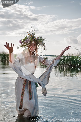 Image of Beautiful woman with flower wreath in water