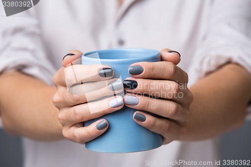 Image of Female hands with blue cup