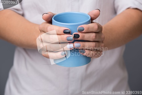 Image of Female hands with blue cup