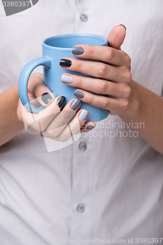 Image of Female hands with blue cup