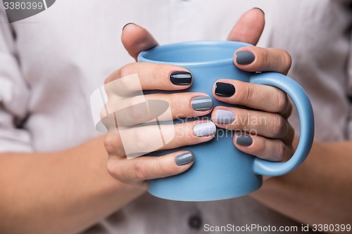 Image of Female hands with blue cup