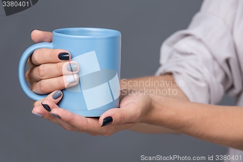 Image of Female hands with blue cup