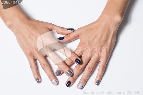 Image of Hand with a stylish gray manicure isolated on white background