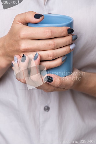 Image of Female hands with blue cup