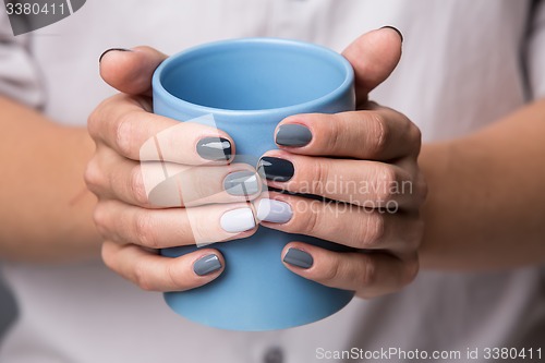 Image of Female hands with blue cup