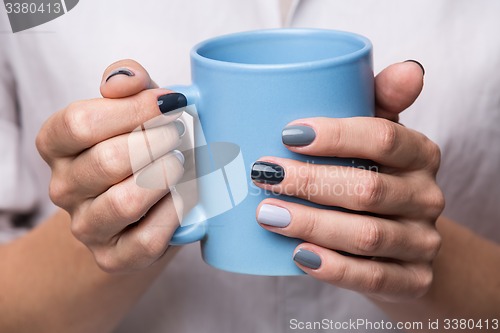 Image of Female hands with blue cup