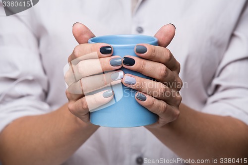 Image of Female hands with blue cup