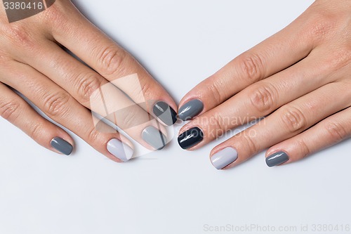 Image of Hand with a stylish gray manicure isolated on white background