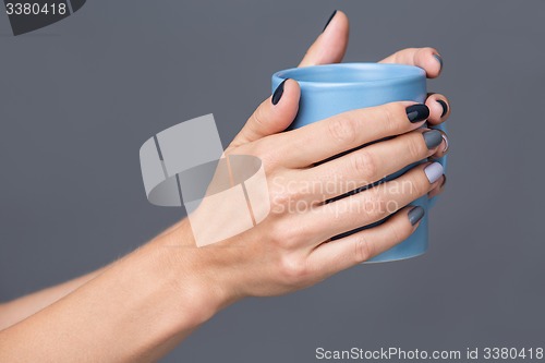 Image of Female hands with blue cup