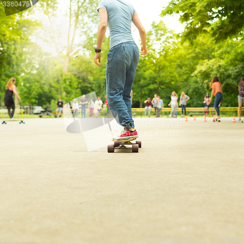 Image of Teenage girl practicing riding long board.