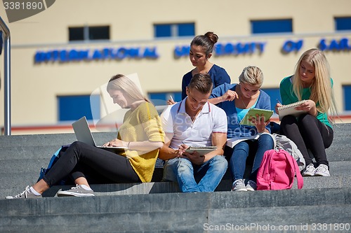 Image of students outside sitting on steps