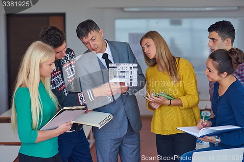 Image of group of students working with teacher on  house model