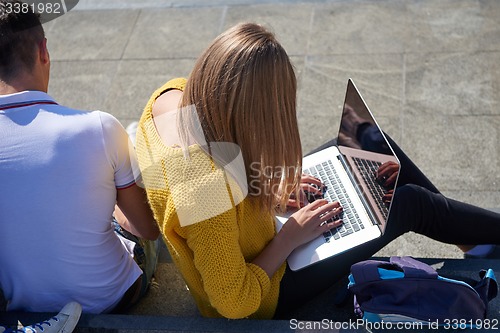 Image of students outside sitting on steps