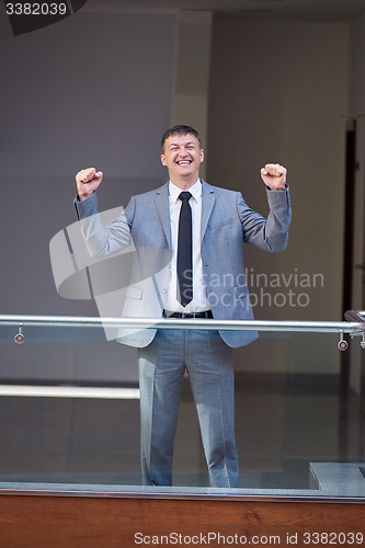 Image of happy business man raise hands from joy