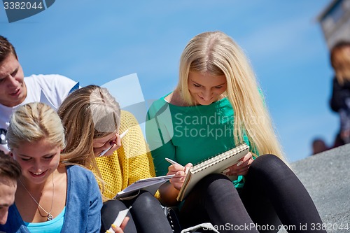 Image of students outside sitting on steps