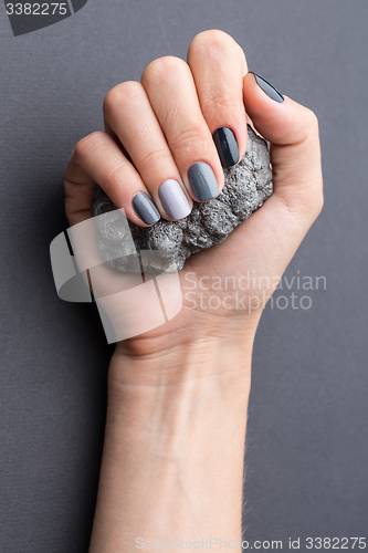 Image of Female hand with textured silver mineral
