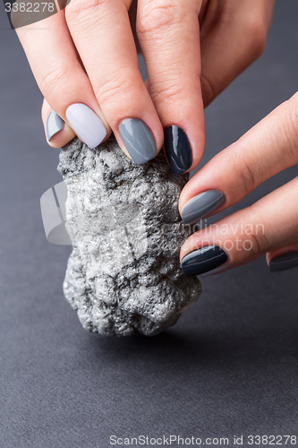 Image of Female hands with textured silver mineral