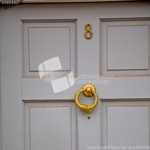 Image of handle in london antique brown door  rusty  brass nail and light