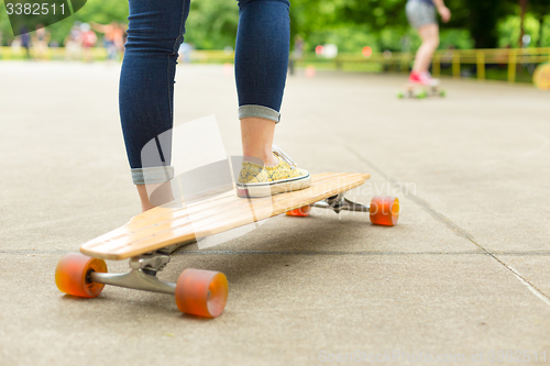 Image of Teenage girl practicing riding long board.