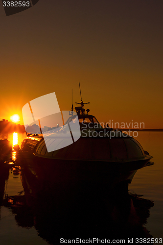 Image of Silhouette of ship in city port on sunset