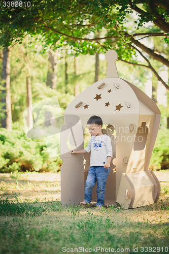 Image of child playing in a cardboard spaceship. Eco concept