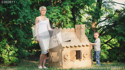 Image of attractive woman in the park with a cardboard house.