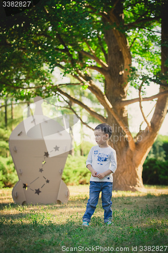 Image of child playing in a cardboard spaceship. Eco concept